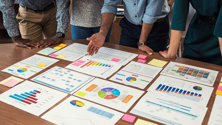 Group of people looking at graphs on a table.jpg