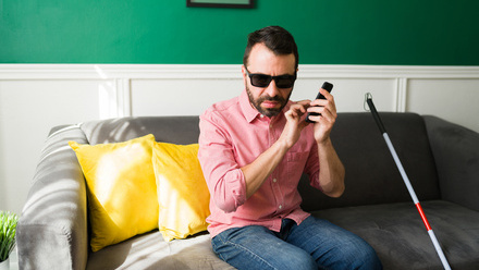 Blind man sitting on a  sofa using phone.jpg