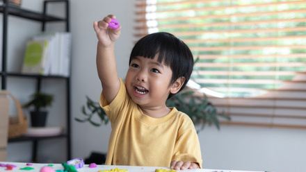Young child playing with clay at a table.jpg
