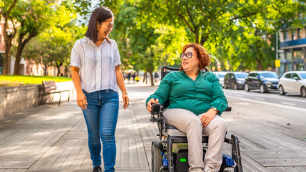 Woman in wheelchair and woman walking in street.jpg