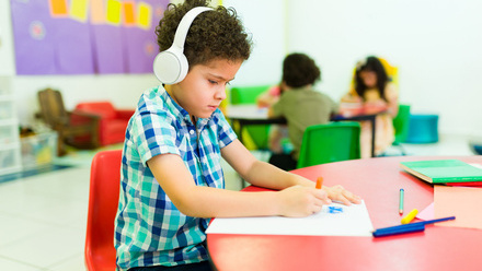 Young boy wearing headphones at table drawing.jpg